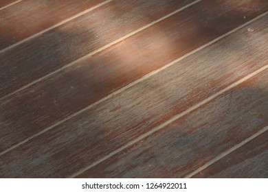 The surface of the plank floor affected the sun at noon.