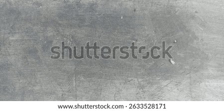 The surface is predominantly a uniform, light to medium gray with subtle variations in tone and very fine lines or striations, possibly from the finishing process.
