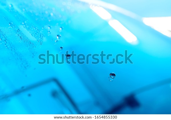 The Surface Protection of the\
car windows at the car wash under the jets of water. Blue\
tone