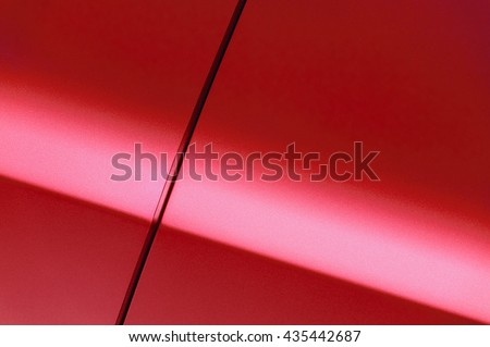 Surface of red sport sedan car, detail of metal fender and door of vehicle bodywork