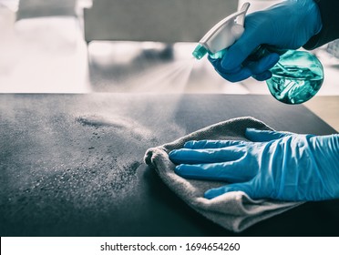 Surface sanitizing against COVID-19 outbreak. Home cleaning spraying antibacterial spray bottle disinfecting against coronavirus wearing nitrile gloves. Sanitize hospital surfaces prevention.