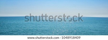 The surface of the sea of ​​the natural blue ocean, with the sunlight from the horizon reflecting on the waves and sparking into a panoramic view.