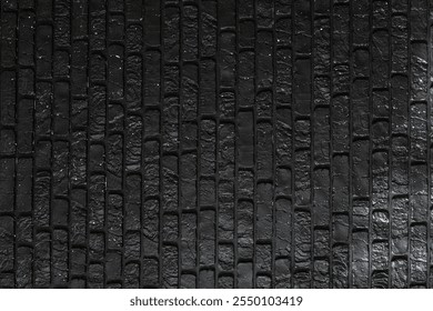 The surface showcases a detailed pattern of black bricks, displaying a unique texture highlighted by soft lighting. This creates a striking visual appeal that captivates attention.