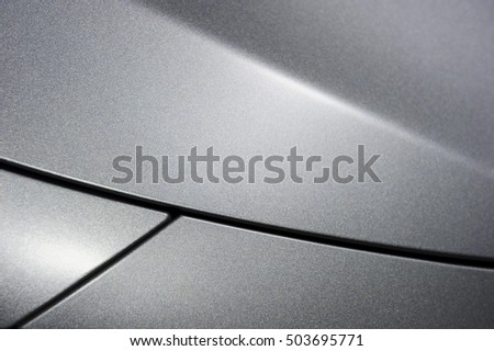 Surface of silver sport sedan car, detail of metal hood and fender of vehicle bodywork