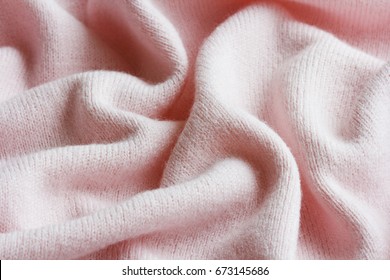 surface of a soft knitted fabric made of cashmere with large folds, a detail of clothes