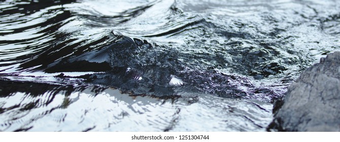 Surface structures on crystal clear flowing water