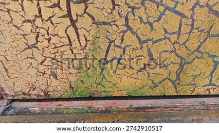 The surface texture is drastically cracked.
This appears to be very old, dry, and peeling paint on a metal surface.
This cracking pattern is often referred to as crazing or a thousand cracks texture. 