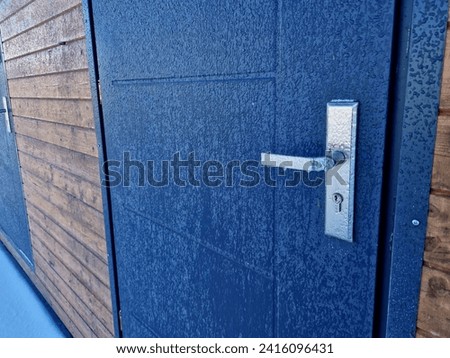 the surface of the wall of the house is a frozen water glaze. frozen plastic door handles and locks. the background of a football club, or the manager of an industrial building
