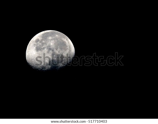 surface of waning gibbous moon on a black sky, view\
from earth