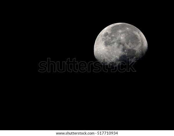 surface of waning gibbous moon on a black sky, view\
from earth