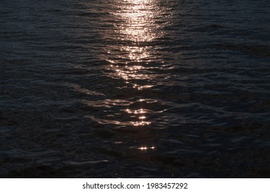 Surface Of The Water, Glare From The Sun. Sunset Or Sunrise At Sea. No Horizon Lines.