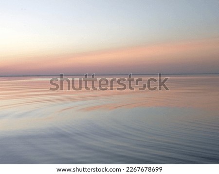 The surface of the water. River, sea, waves, smooth surface. Sea at sunset, pink sunset. Water texture, background.