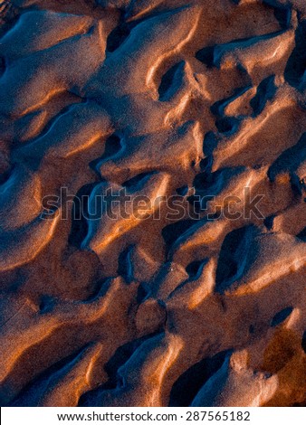 Surface of a wet moist sand bottom in sunset light