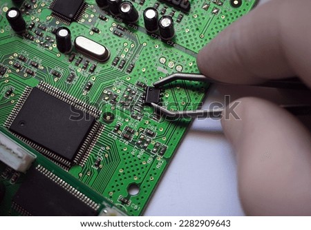 Surface-mount chip removed from electronic circuit board. Micro electronic, semiconductor industry background.