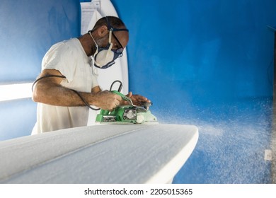 Surfboard craftsman shaping boards in his shaping workshop - Powered by Shutterstock