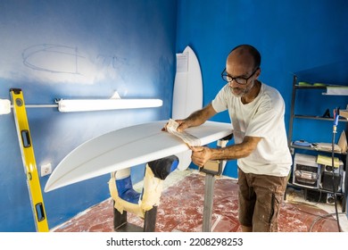 Surfboard craftsman shaping boards in his shaping workshop - Powered by Shutterstock