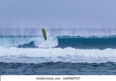 Surfboard Hovers Over Breaking Wave After Epic Wipeout