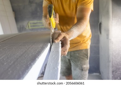 Surfboard making, woodworker wearing safety respirator sawing surfboard blank using handsaw - Powered by Shutterstock