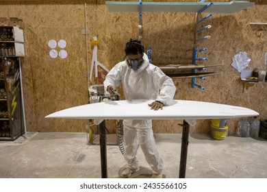 Surfboard manufacturing, Shaper working on board details. Concept of industrial manufacturing, qualified professional, occupation and employment. - Powered by Shutterstock