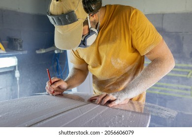 Surfboard Modeling Workshop - Man perfecting the modeling of a surfboard - Powered by Shutterstock