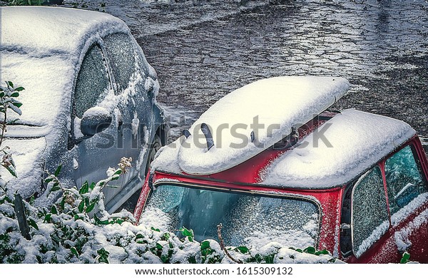 surfboard on a car roof\
covered by snow