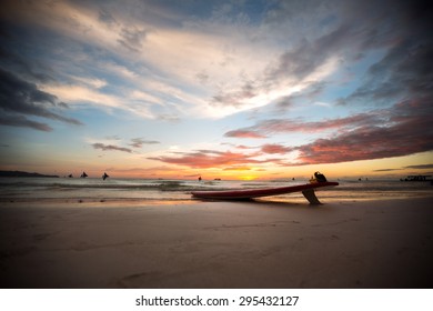 
surfboard on a deserted beach at sunset  - Powered by Shutterstock