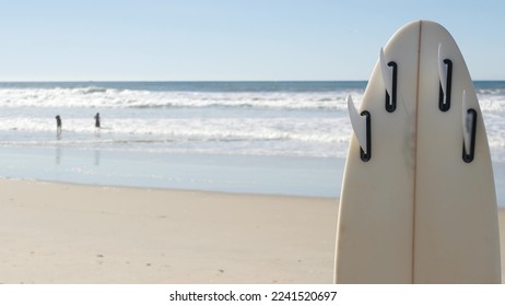 Surfboard for surfing standing on beach sand, California coast, USA. Ocean wave and white surf board or paddleboard. Longboard or sup for watersport by sea water. Summer vacation, sport on shore vibes - Shutterstock ID 2241520697