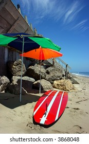 Surfboard and umbrellas on California beach