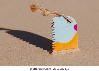 Surfboard wax comb on the sand - Shutterstock ID 2311289117