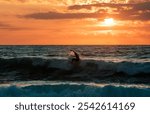 Surfer in action under a beautiful panoramic ocean sunset