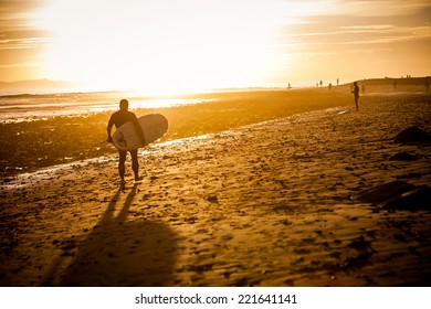 Surfer At The Beach At Sunset