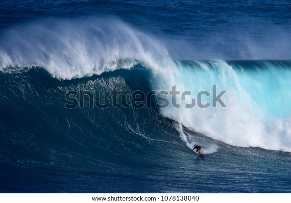 A surfer catches a massive wave at\
Peahi, also known as Jaws, off Maui\'s eastern\
shore.