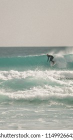 Surfer Catching A Wave Over A Sandy Beach At Wedge Island