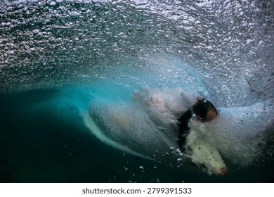 Surfer caught inside a powerful breaking barrel with swirling water and bubbles at Bondi Beach, Sydney, Australia.