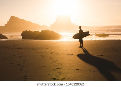 Surfer checking the waves at sunset