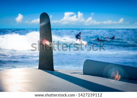 Surfer desk and blurred background of sea with blue sky. Summer time and water sports. 
