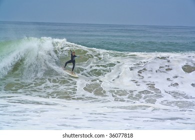 A Surfer drops into a Wave going Backside