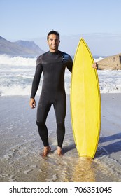 Surfer Dude In Wetsuit Standing With Board On Beach