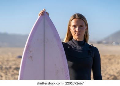 Surfer girl at the beach with her surfboard. Female surfer woman - Powered by Shutterstock