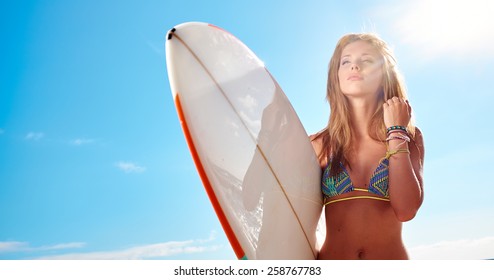surfer girl posing with her surfboard
