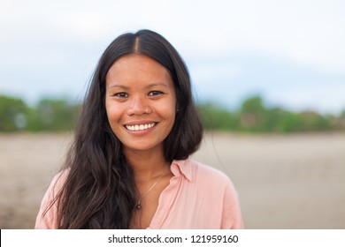 surfer girl posing on the beach and smiling - Powered by Shutterstock