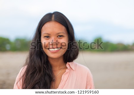 surfer girl posing on the beach and smiling