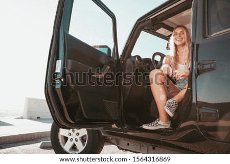 surfer girl sitting in car at the beach. california