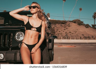 Surfer Girl Standing By A Car On Parking Spot. California