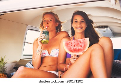 Surfer Girls Beach Lifestyle, Friends Hanging out Eating Watermelon in the Back of Classic Vintage Surf Van on the Beach at Sunset 