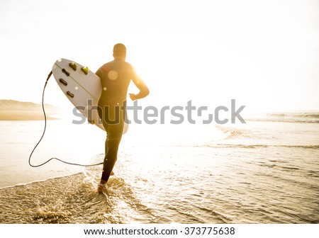 A surfer with his surfboard running to the waves