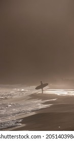 Surfer Holding Board In Sunset Beach Shore