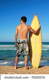 Surfer Holding A Surf Board On Beach