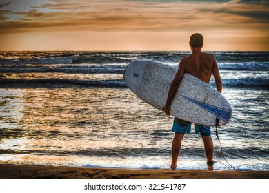 Surfer Holding A Surfboard On The Beach In Hdr