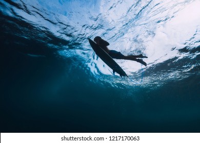 Surfer male with surfboard dive underwater with under big wave.